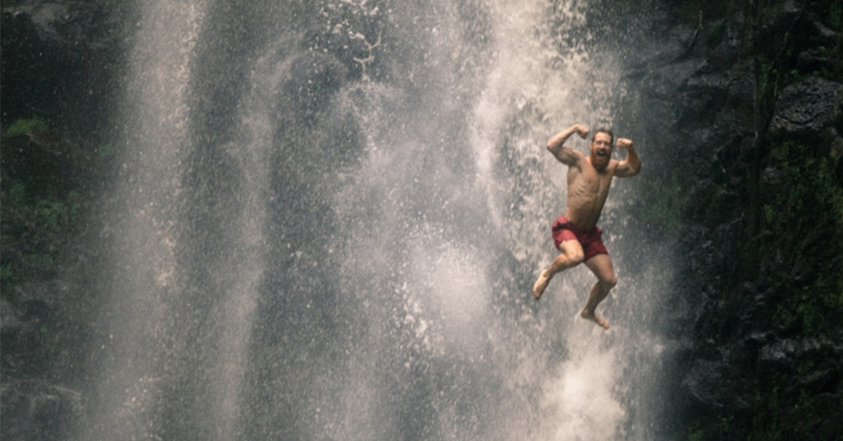 Man celebrating in waterfall